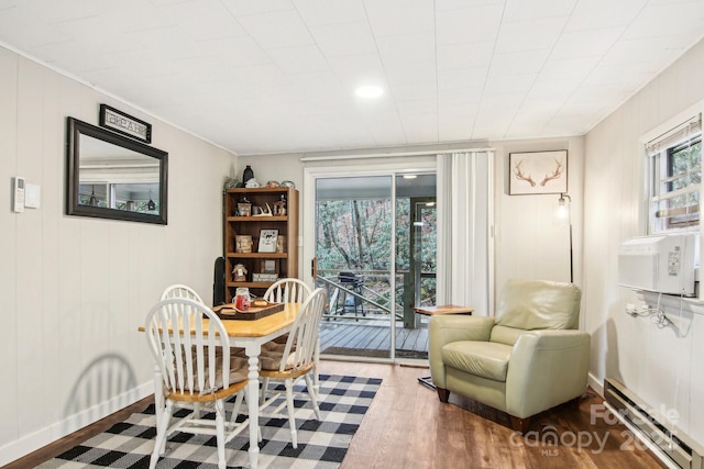 dining space with hardwood / wood-style flooring, cooling unit, and a baseboard heating unit