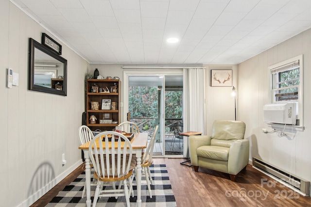 dining area featuring hardwood / wood-style floors, cooling unit, baseboard heating, and a healthy amount of sunlight