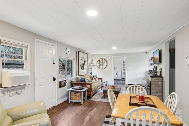 dining space featuring a healthy amount of sunlight, cooling unit, and dark wood-type flooring