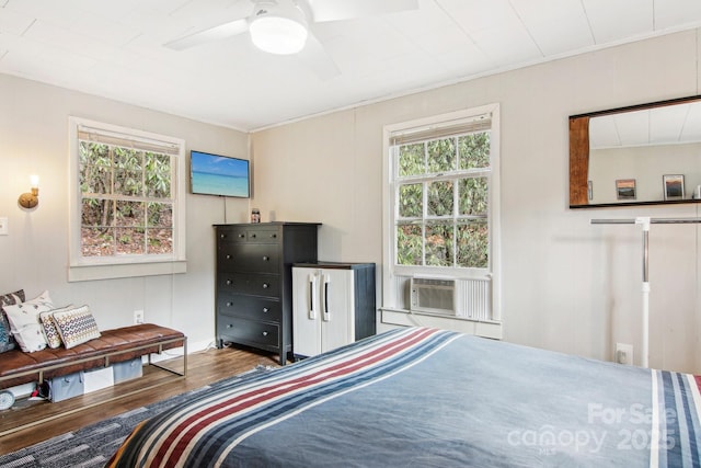 bedroom with ceiling fan, cooling unit, and wood-type flooring