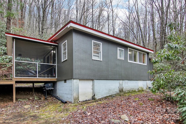 view of property exterior with a sunroom and a deck