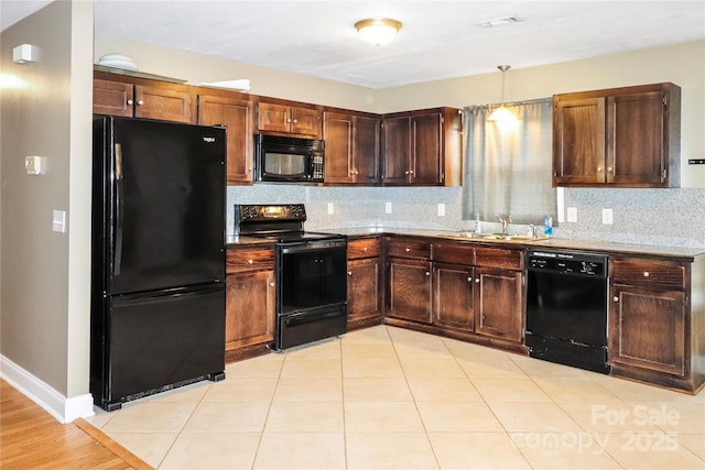 kitchen featuring tasteful backsplash, sink, black appliances, light tile patterned floors, and hanging light fixtures