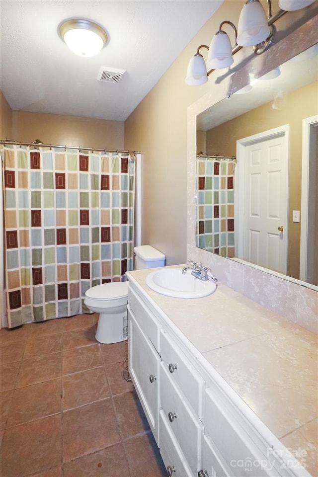 bathroom featuring tile patterned flooring, vanity, and toilet