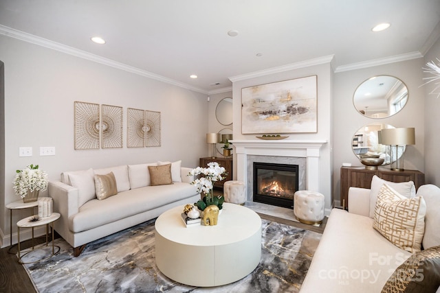 living room featuring a premium fireplace, wood-type flooring, and ornamental molding