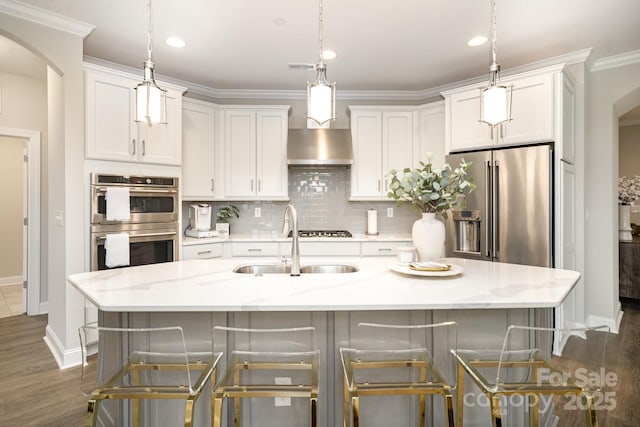 kitchen with light stone countertops, appliances with stainless steel finishes, a center island with sink, and sink