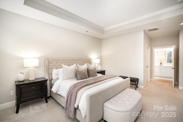 bedroom featuring a tray ceiling, connected bathroom, light colored carpet, and ornamental molding