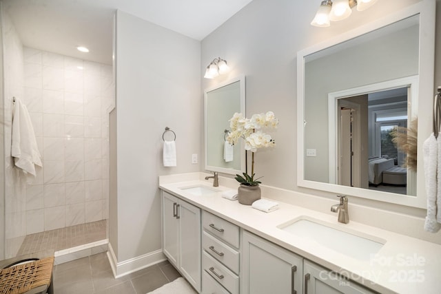 bathroom featuring tile patterned flooring, vanity, and tiled shower