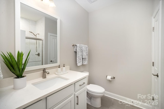 bathroom with tile patterned flooring, vanity, a shower with shower door, and toilet