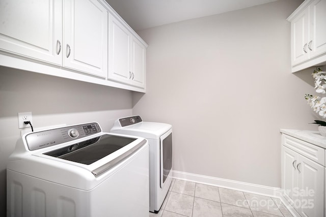 washroom with washer and dryer, light tile patterned flooring, and cabinets