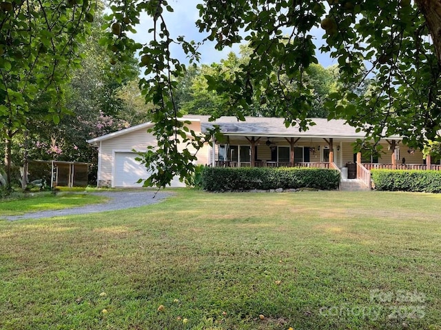 single story home featuring a porch, a front yard, driveway, and an attached garage