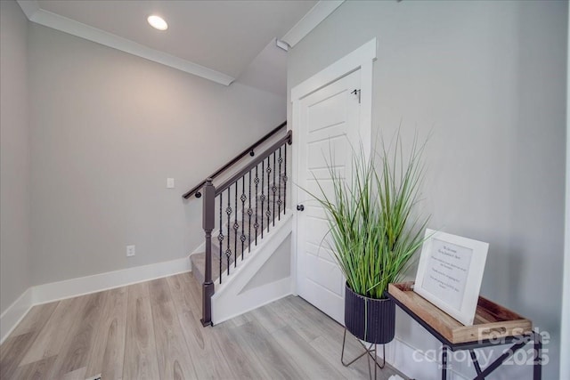 stairway featuring crown molding and hardwood / wood-style floors