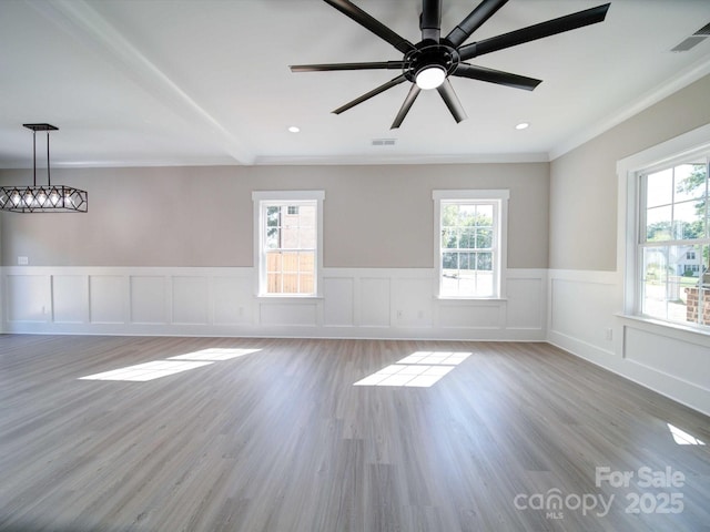 empty room with hardwood / wood-style flooring, a wealth of natural light, and ceiling fan