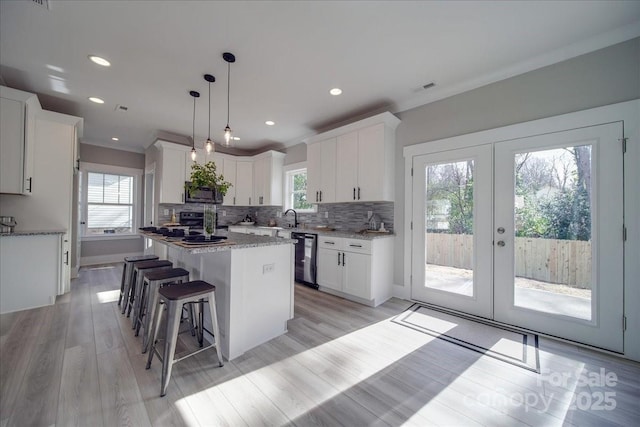 kitchen with a center island, french doors, tasteful backsplash, decorative light fixtures, and white cabinets