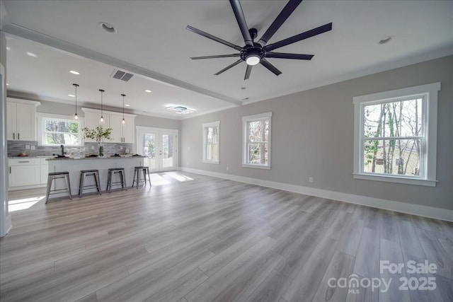 unfurnished living room with ceiling fan, light hardwood / wood-style floors, and french doors