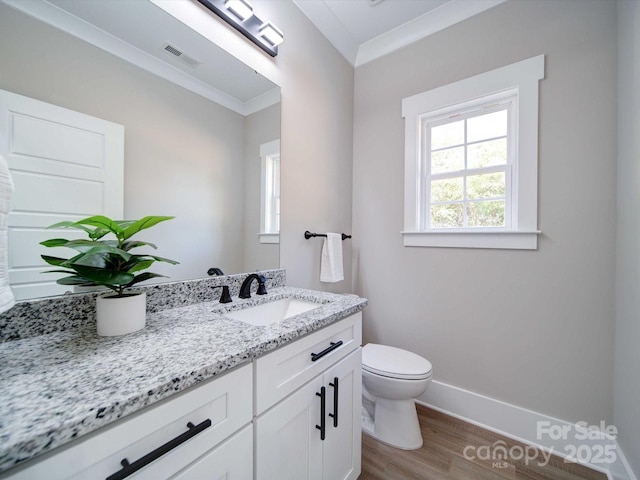 bathroom featuring toilet, vanity, wood-type flooring, and ornamental molding