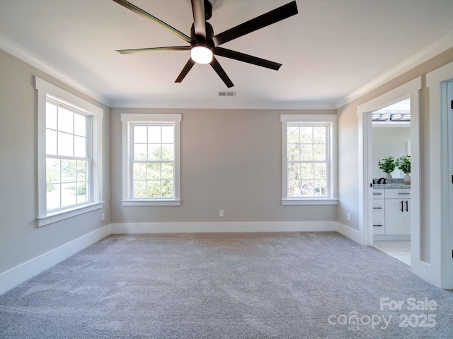 carpeted spare room with ceiling fan and crown molding