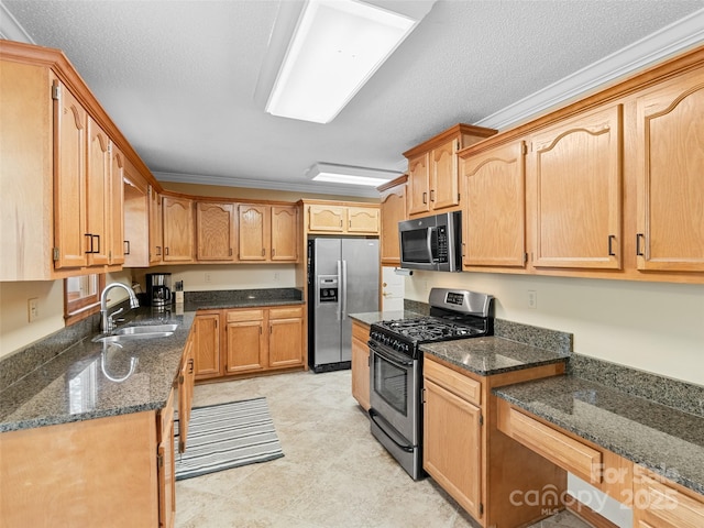 kitchen featuring dark stone counters, stainless steel appliances, crown molding, and sink