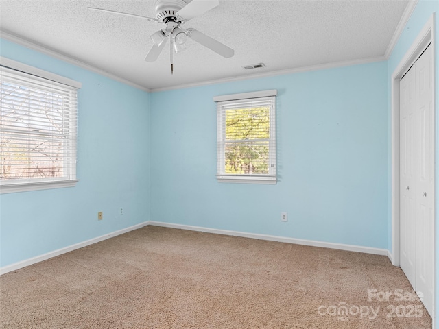 unfurnished bedroom with ceiling fan, ornamental molding, light carpet, and a closet