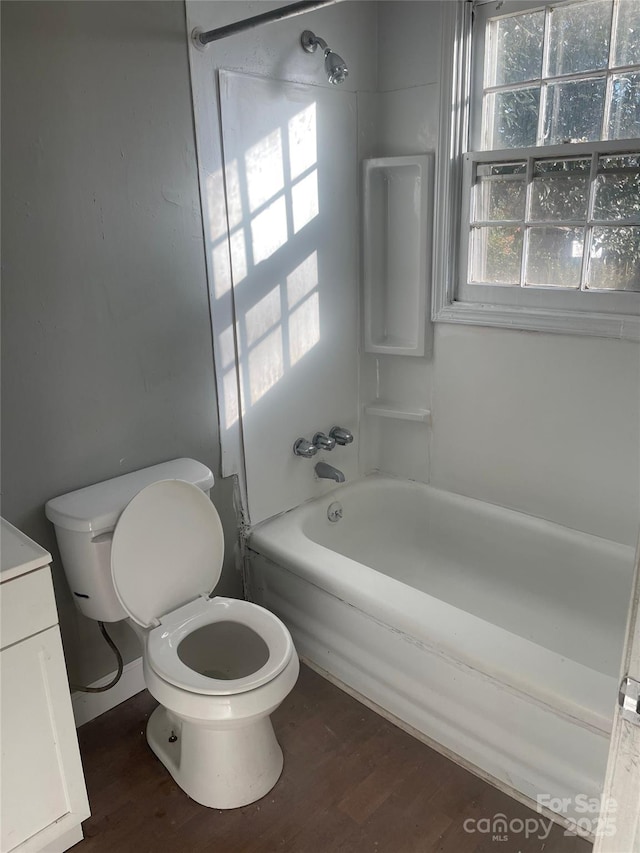 full bathroom with bathing tub / shower combination, vanity, wood-type flooring, and toilet