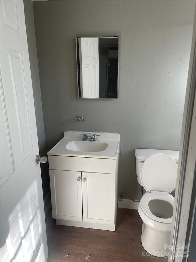 bathroom with vanity, hardwood / wood-style flooring, and toilet