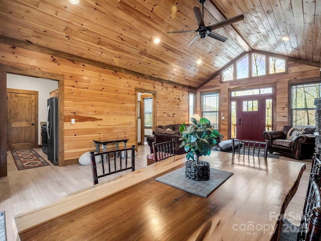 dining room with wood walls, a healthy amount of sunlight, wood-type flooring, and wood ceiling