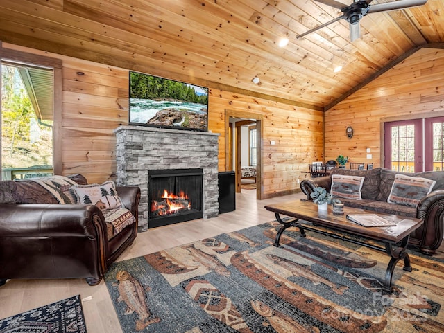 living room featuring light wood-type flooring, vaulted ceiling, a wealth of natural light, and wood ceiling