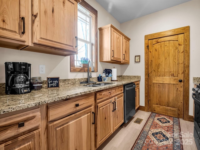 kitchen featuring black appliances, light wood-type flooring, light stone countertops, and sink