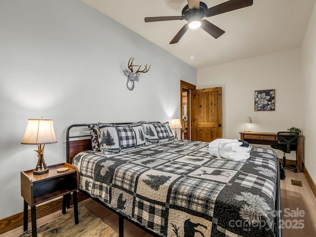 bedroom with ceiling fan, light hardwood / wood-style floors, and vaulted ceiling