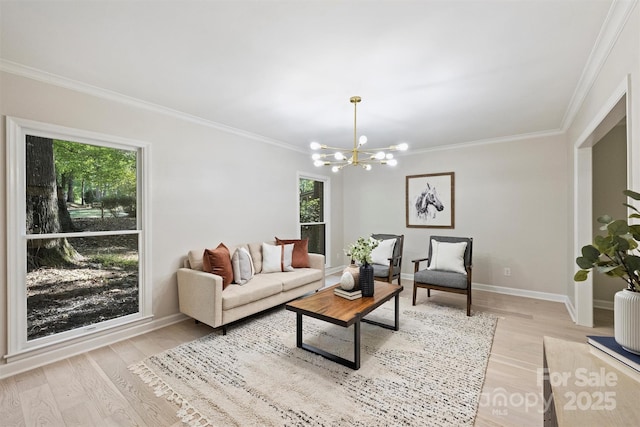 living room featuring light wood-type flooring, an inviting chandelier, a healthy amount of sunlight, and crown molding