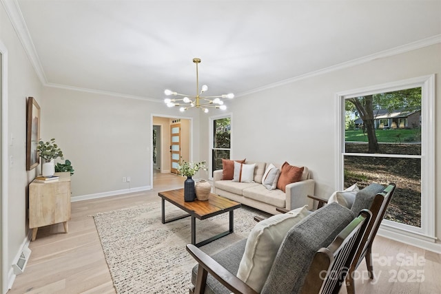 living room with light hardwood / wood-style floors, an inviting chandelier, and ornamental molding