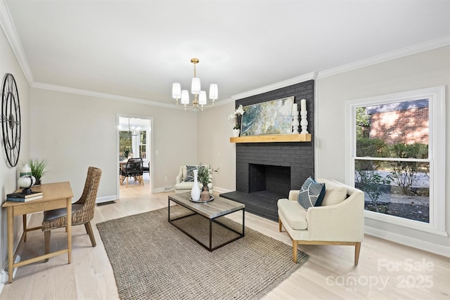 living room with a chandelier, hardwood / wood-style flooring, a brick fireplace, and crown molding