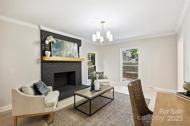 living room with a notable chandelier, wood-type flooring, ornamental molding, and a brick fireplace