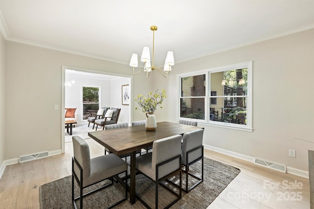 dining area with a chandelier, light hardwood / wood-style flooring, and crown molding