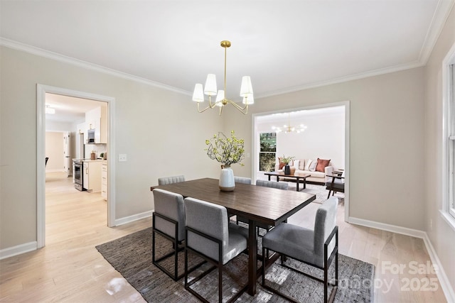 dining room with ornamental molding, light wood-type flooring, and an inviting chandelier