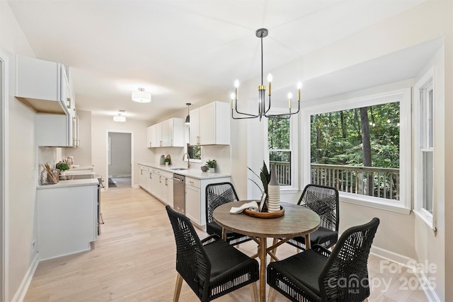 dining room featuring light hardwood / wood-style flooring, a notable chandelier, and sink