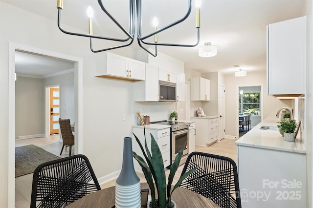 kitchen with white cabinetry, sink, an inviting chandelier, crown molding, and stainless steel electric range