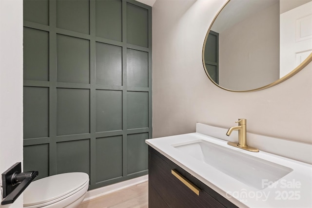 bathroom with vanity, toilet, and wood-type flooring