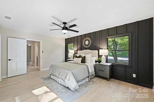 bedroom with multiple windows, light hardwood / wood-style floors, and ceiling fan