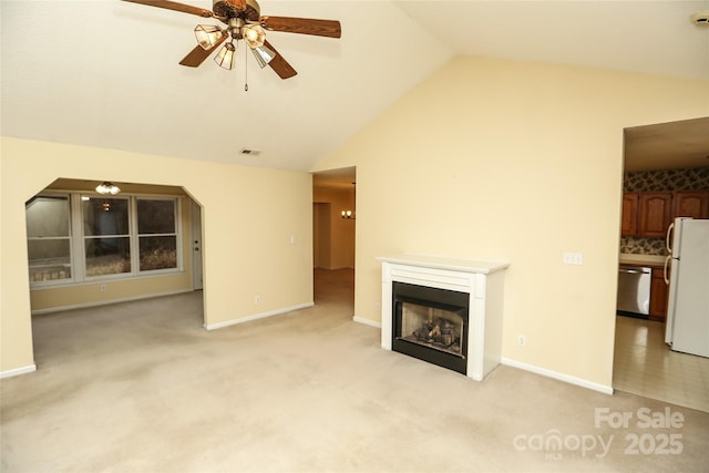 unfurnished living room featuring ceiling fan, lofted ceiling, and light carpet