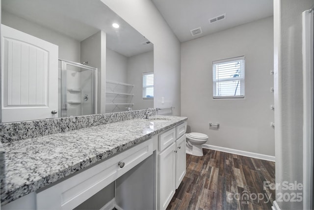 bathroom featuring hardwood / wood-style floors, vanity, toilet, and an enclosed shower