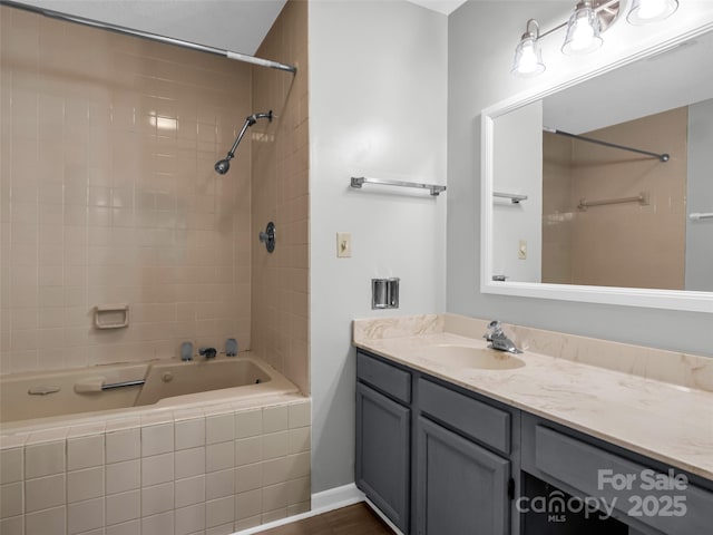 bathroom with tiled shower / bath combo and vanity