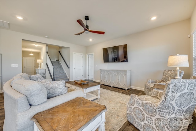 living room featuring ceiling fan and dark hardwood / wood-style floors