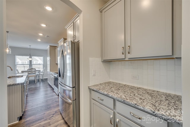 kitchen with sink, tasteful backsplash, decorative light fixtures, dark hardwood / wood-style flooring, and stainless steel fridge with ice dispenser