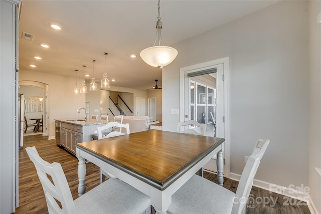 dining room featuring dark hardwood / wood-style floors, ceiling fan, and sink