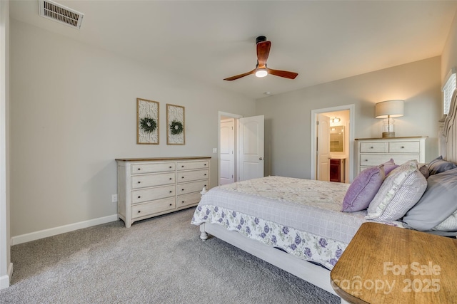 bedroom with light colored carpet, ensuite bath, and ceiling fan