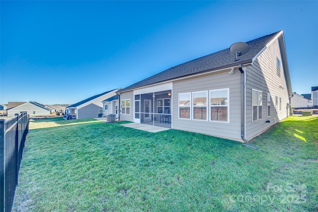 back of house with a sunroom and a yard