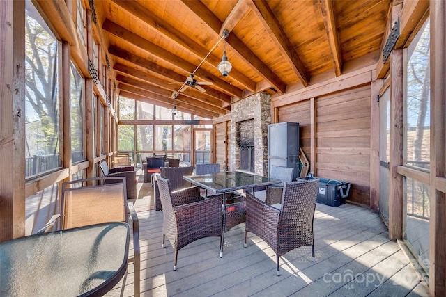 sunroom featuring lofted ceiling with beams, a healthy amount of sunlight, wooden ceiling, and ceiling fan