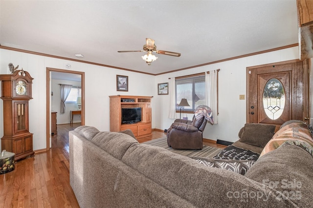 living room with hardwood / wood-style flooring, ceiling fan, and crown molding