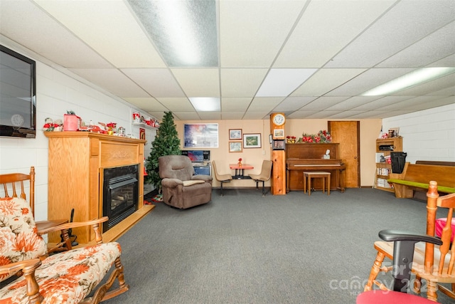 carpeted living room with a drop ceiling