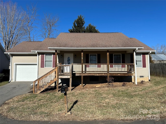 ranch-style house featuring a front lawn, covered porch, and a garage